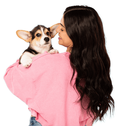 A woman holding a corgi