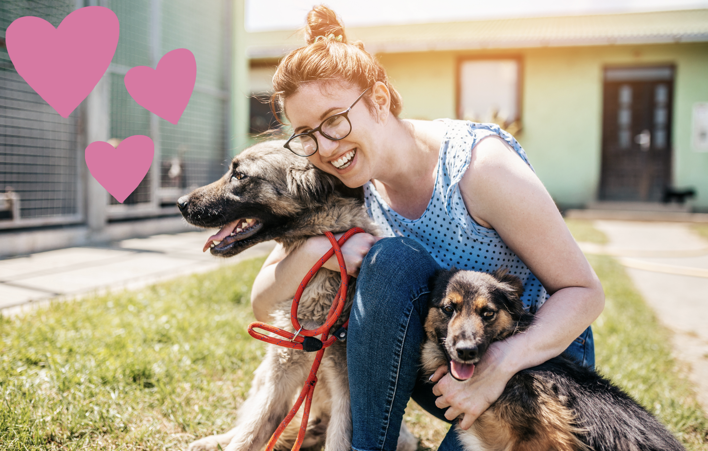 Smiling woman with her arms around two tan and black dogs with a red leash between them